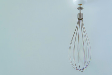 Isolated stainless kitchen utensil - the whisk on white background with space for text.