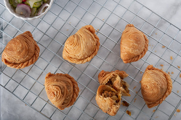 Traditional curry puffs stuffed chicken on table as background