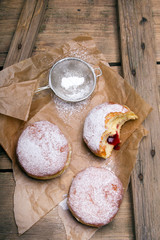 Traditional Polish donuts on wooden background. Tasty doughnuts with jam.
