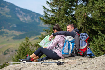Smiling adventure couple with map on slope. look at map
