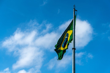 Brazilian Flag Waving Against a blue sky background.