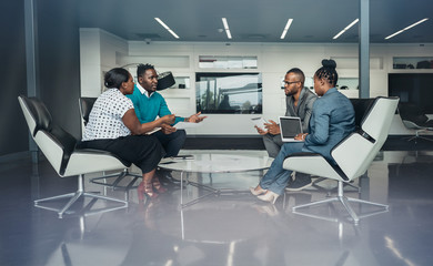 Team of african bussines people sitting in a modern office and talking during an work meeting