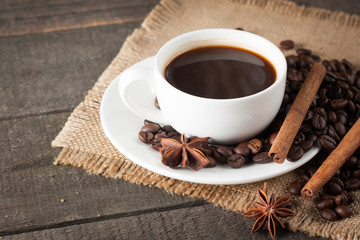 Coffee cup and beans on a rustic background. Coffee Espresso and a piece of cake with a curl. Cup of Coffee and coffee beans on table.