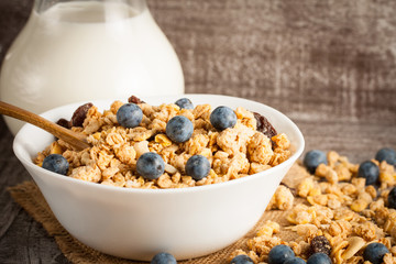 Healthy breakfast concept with oat flakes and fresh berries on rustic background. Food made of granola and muesli. Healthy banana smoothie with blackberries, honey and milk.