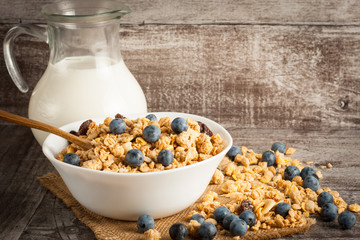 Healthy breakfast concept with oat flakes and fresh berries on rustic background. Food made of granola and muesli. Healthy banana smoothie with blackberries, honey and milk.