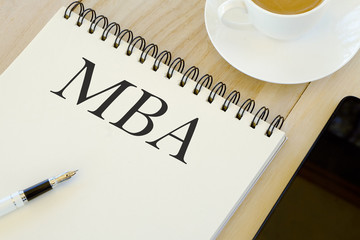 Education concept. Mobile phone,a cup of coffee,pen and notebook written with MBA.
