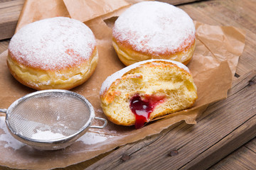 Traditional Polish donuts on wooden background. Tasty doughnuts with jam.