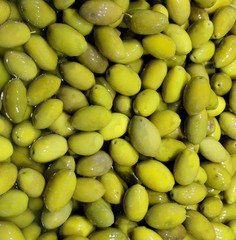 background of green olives in brine for sale at the stand of foo