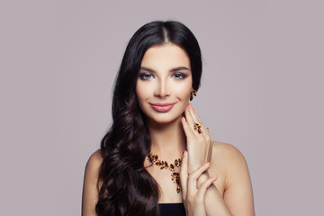 Fashion woman portrait. Girl with gold necklace, ring and earrings with amber on pink