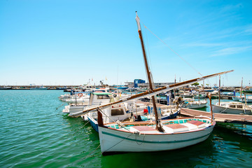 Fototapeta premium old sea fishing boat in the port with a deflated sail