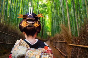 Panele Szklane  Kobieta w tradycyjnym kimonie spacerująca w bambusowym lesie Arashiyama, Japonia