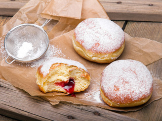 Traditional Polish donuts on wooden background. Tasty doughnuts with jam.