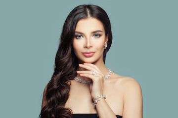 Glamorous model woman with silver jewelry on blue background