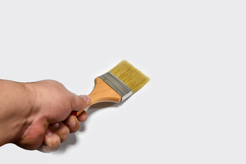 Paint brush in hand isolated on white