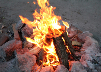 Bonfire in a tourist camp lined with stones around the hill