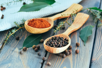 Red and black allspice on the background of a wooden table. Traditional Mediterranean cuisine