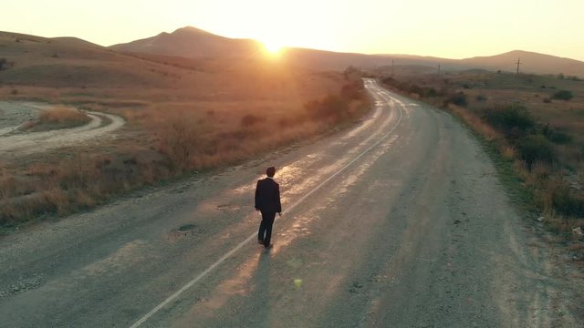 Man in suit walking away by the road