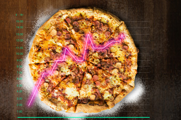 Pizza on wooden table with chart. Increased sales of pizza concept.