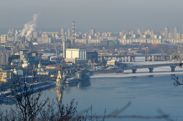 Fototapeta na wymiar Winter misty view of Dnieper river and Podol district with promenade and buildings. Kiev, Ukraine