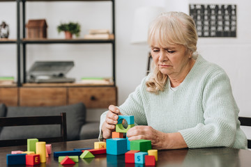 senior woman playing with wooden toys at home