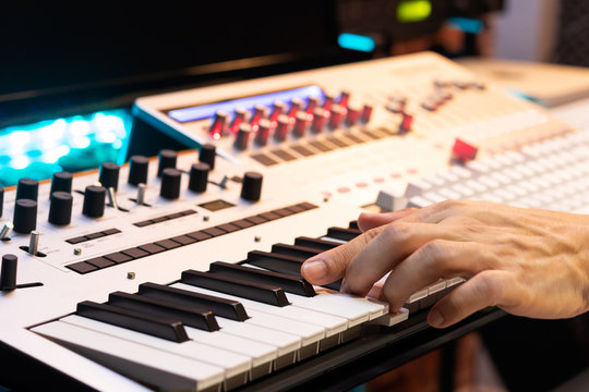 producer hands playing on midi keyboard synthesizer for recording in post production studio