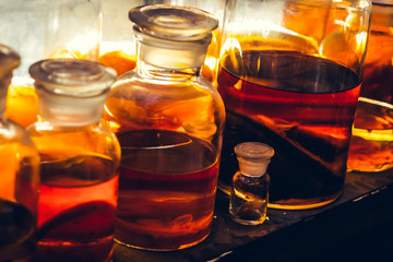 Halloween. Three glass containers with colorful slime liquid and fall leaves. Hallow's Eve witchcraft magic concept