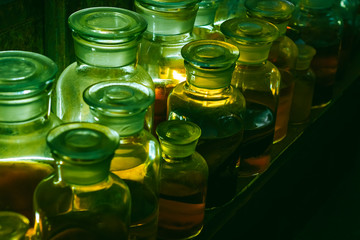 Halloween. Three glass containers with colorful slime liquid and fall leaves. Hallow's Eve witchcraft magic concept