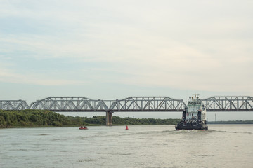 Iron barge and pusher tug boat on River. Large cargo barge transporting iron to main harbor for...
