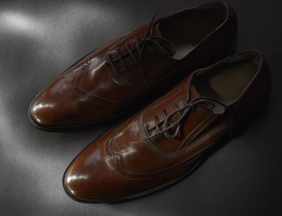brown leather shoes on gray background