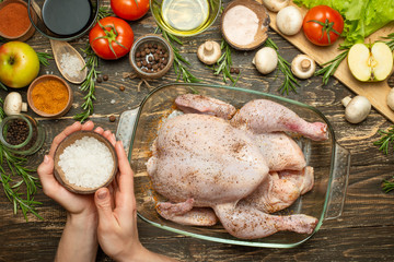 Cooking fresh chicken for a festive dinner, the hands of the chef salt and pepper the chicken concept recipe book, menu, restaurant business. Background, top view, Flat-lay