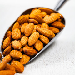 Scoop Full of Organic Raw Almonds Nuts. Selective focus.