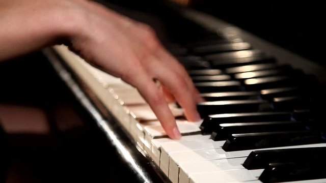 Two hands playing  on a beautiful grand piano.