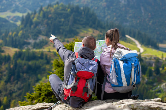 Smiling adventure couple with map on slope. look at map