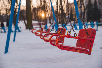 child swings on sunset in city park
