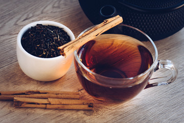 Cup of tea and kettle, iron, dry leaves and cinnamon