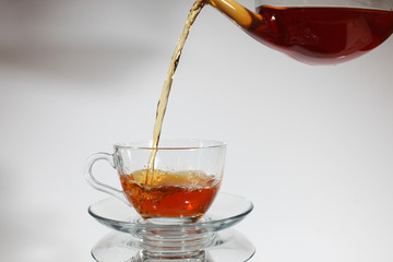 Pouring tea to a teacup.