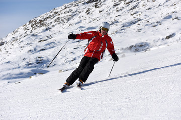 Skier skiing downhill during sunny day in high mountains. Italy, Europe.