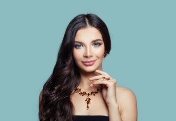 Cute brunette woman smiling on blue background, fashion portrait