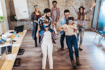 Business people making team training exercise during team building seminar, play a game of trust