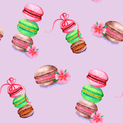 Colorful watercolor macaroons with flowers and bows on a pink background.  Hand drawn illustration. Seamless pattern.