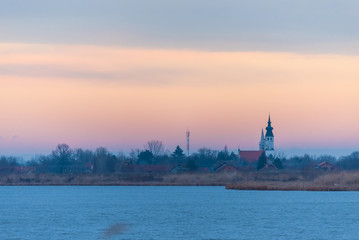 Fototapeta na wymiar two churches in the village by the lake