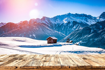 Old wooden table in the snowy mountains. Alps with a free place for an advertising product  