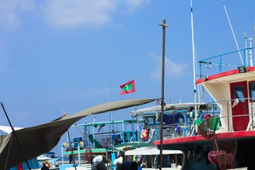 Maldivian flag over the harbor in Male fish market (Maldives, Asia)