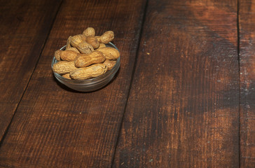 Peanuts in nutshell on a piece of wood