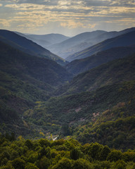 Huge valley surrounded by mountains covered with forest