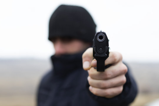 Man shooting from a gun, robber commits a crime, criminal concept