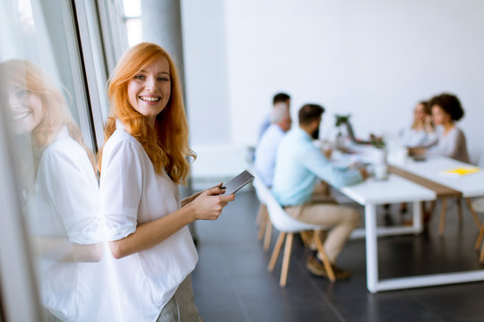 Pretty young red hair woman using digital tablet