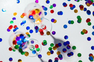 Minimalistic festive background with champagne in glasses and confetti
