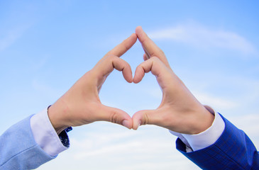 Hands put together in heart shape blue sky background. Love symbol concept. Male hands in heart shape gesture symbol of love and romance. Hand heart gesture forms shape using fingers