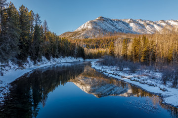 Fototapeta na wymiar Peaceful calm sunny day at McDonald Creek, Glacier National Park, Montana in December